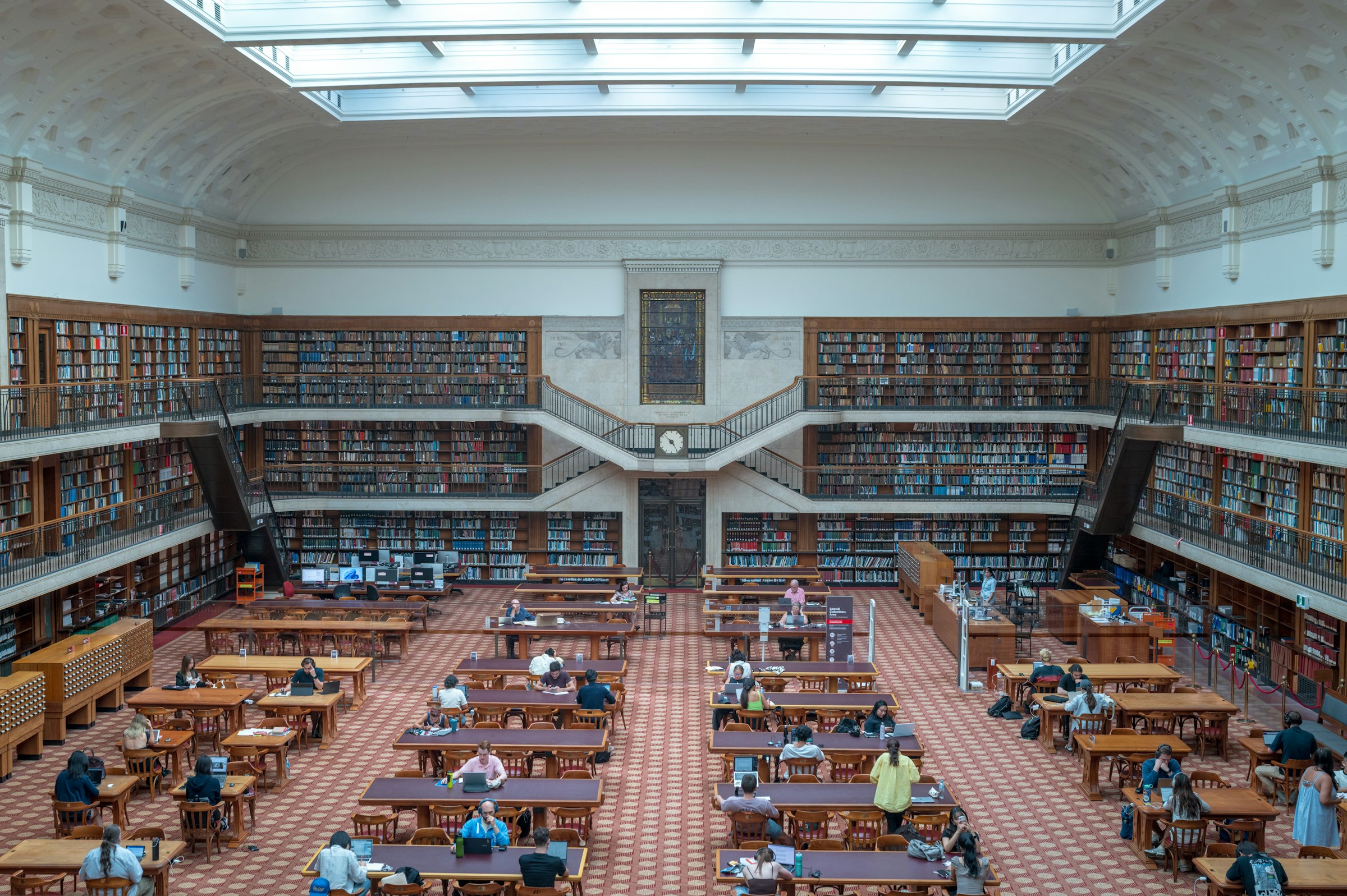 People studying and working in a large institutional library