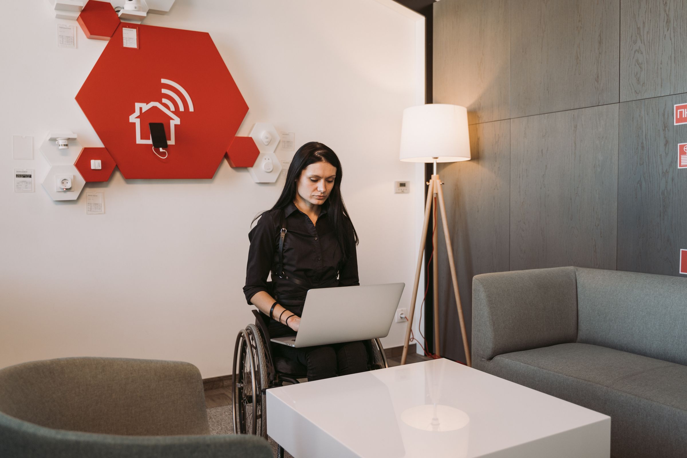 Professional using a laptop from a wheelchair in a modern workspace